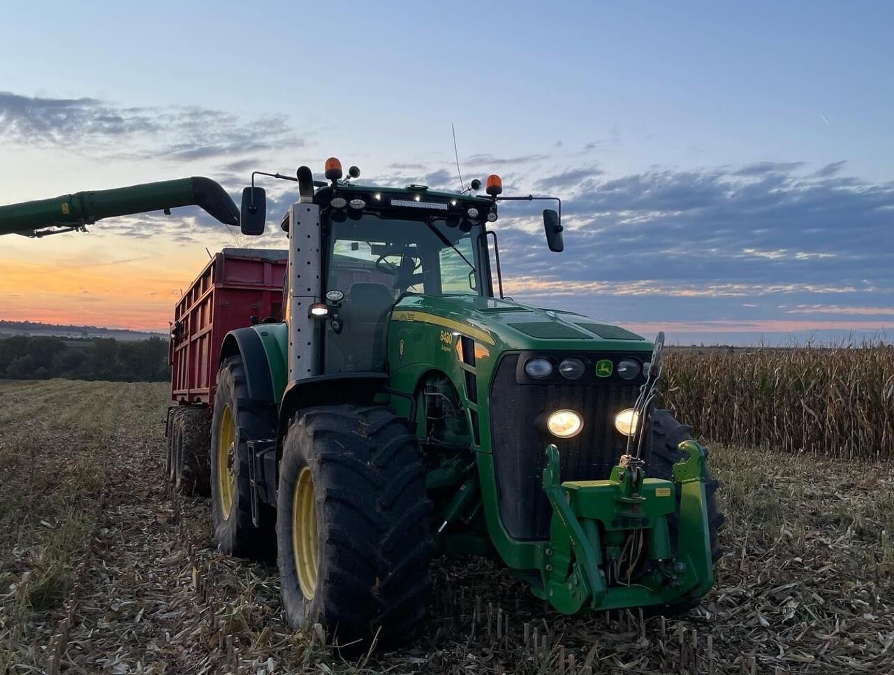 John Deere 8430 při sklizni za soumraku