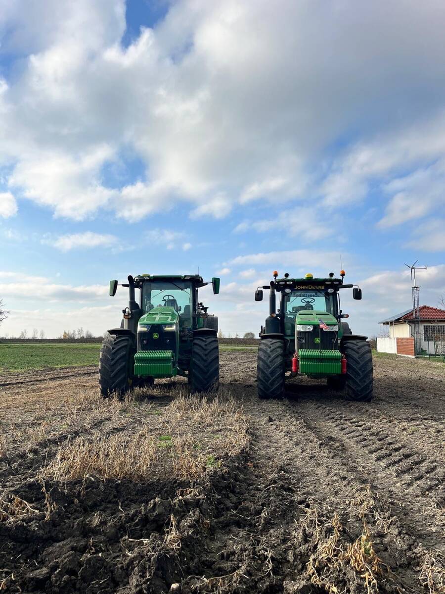 Dva traktory John Deere na poli