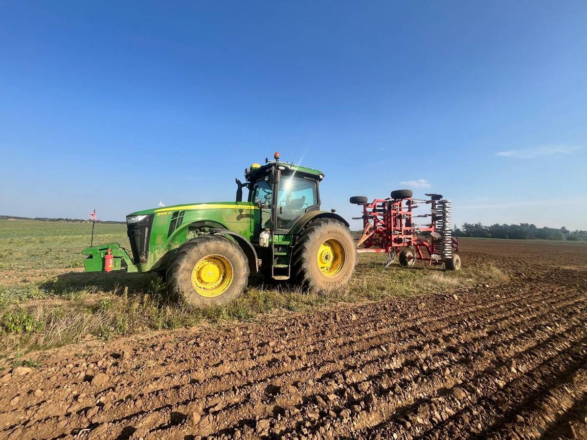 John Deere 8335R s červeným kypřičem