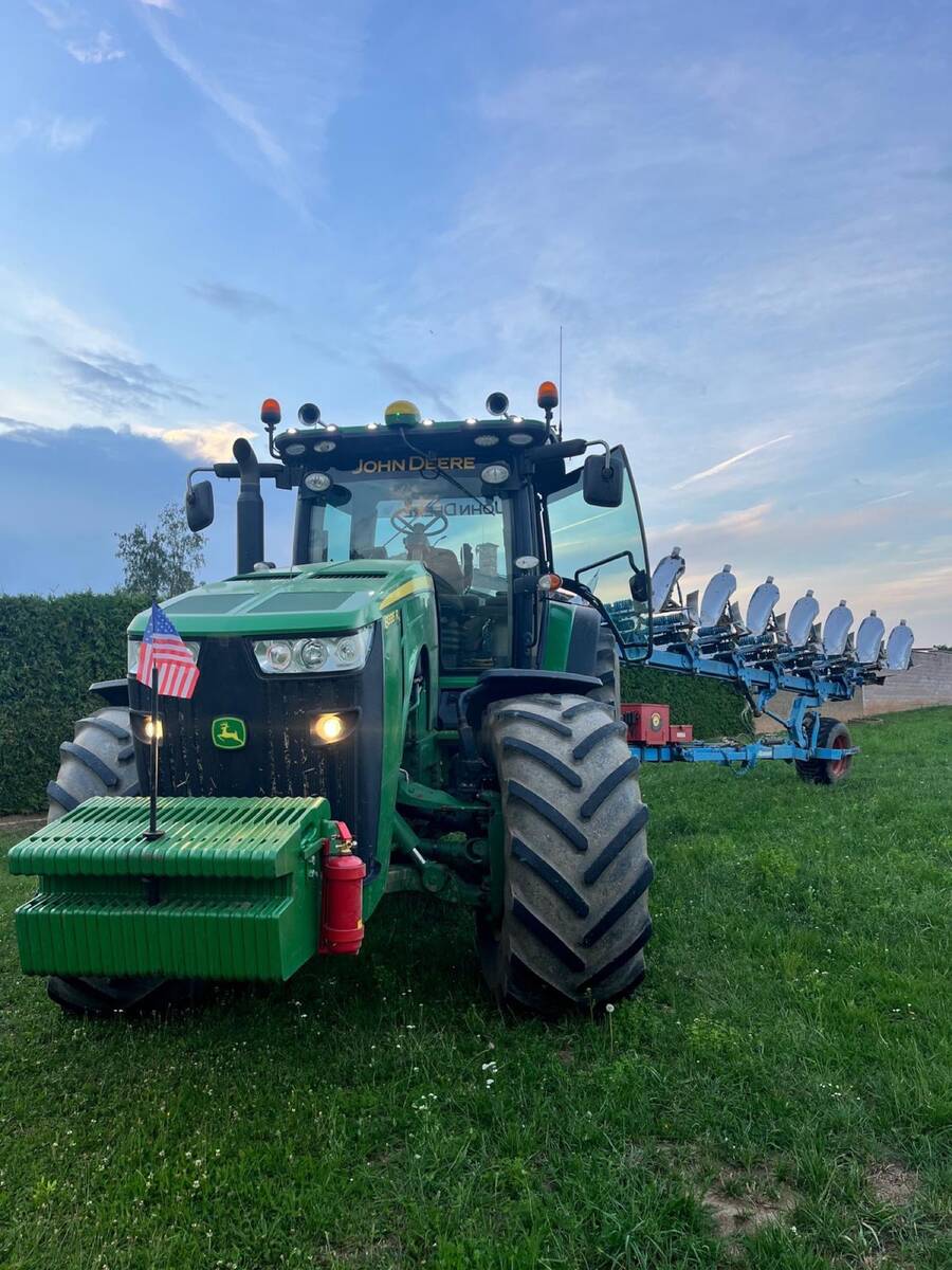 John Deere 8335R s pluhem za soumraku