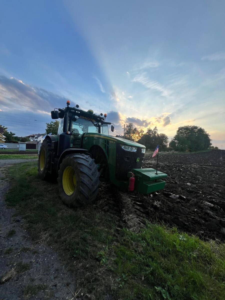 John Deere 8335R při západu slunce